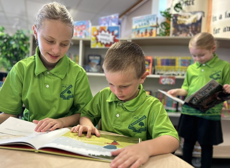 Year 6 student and Kindergarten student reading