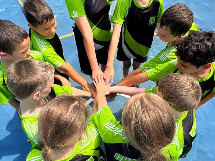 students in circle with hands in