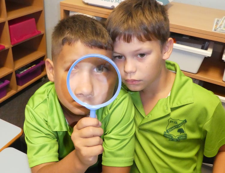 students with magnifying glass
